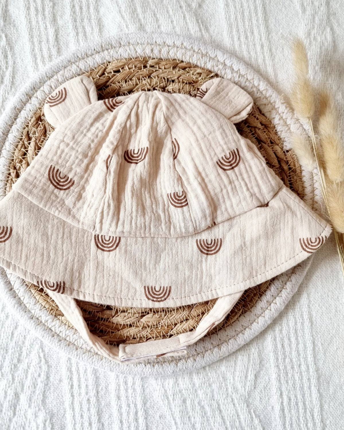 Musselin solhat til baby - beige med regnbuemønster
